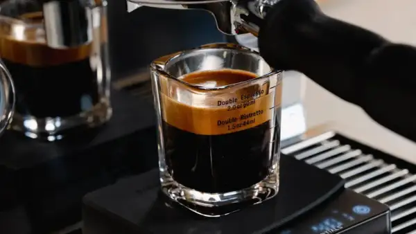 A double ristretto and double espresso in a glass shot with measurement markings.