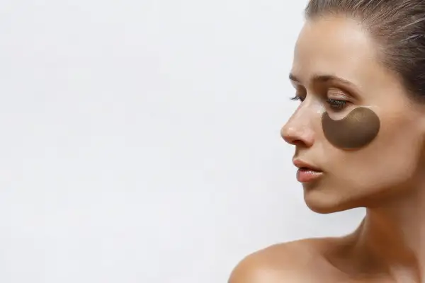 Kobieta z płatkami pod oczy. Czy retinol można stosować pod oczy? Płatki nawilżają i odżywiają delikatną skórę.