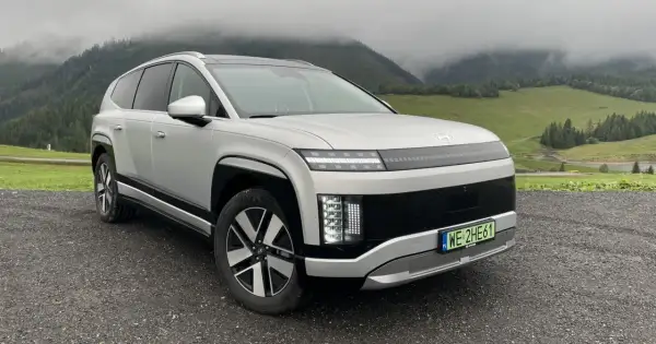 Srebrny Hyundai Ioniq 9 na tle mglistych gór i zielonych łąk.