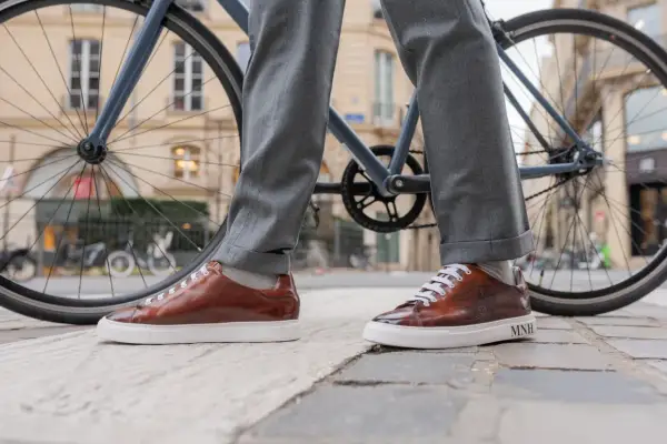 Eleganckie, brązowe sneakersy do garnituru, idealne na miejską przejażdżkę rowerem.