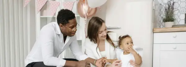 Famille célébrant la tradition du baptême. Un père, une mère et leur bébé, entourés de décorations festives.