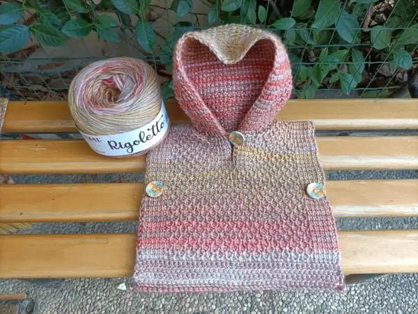 Uncinetto magico per un poncho colorato, con gomitolo Rigoletto e bottoni decorativi.