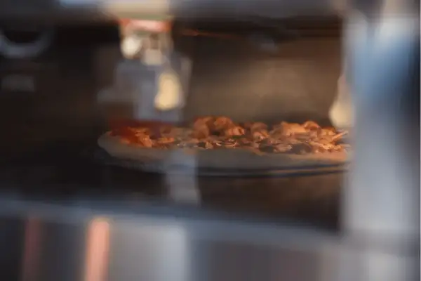 Pizza Dr. Oetker piecze się w piekarniku, parując apetycznie. Czas pieczenia zależy od modelu.