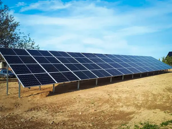 Długa instalacja fotowoltaiczna na stelażach, gotowa do zbierania energii słonecznej.