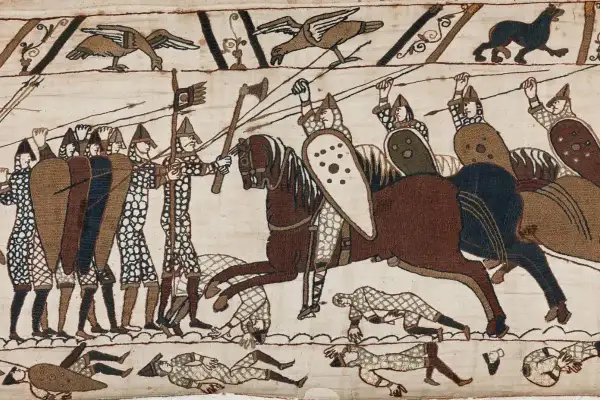 Scen från slaget vid Hastings 1066. Soldater med sköldar och spjut, en ryttare på häst. Nedanför fallna krigare.