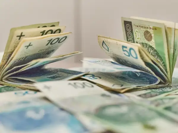 Pieniądze, banknoty 100 i 50 zł, leżące na stole. Może to być dodatek aktywizacyjny dla pracowników.