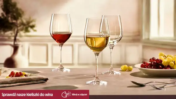 Eleganckie kieliszki do wina, jeden z czerwonym winem, drugi z białym, gotowe na degustacje. Obok winogrona i sztućce.