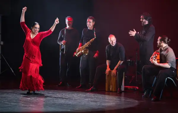 Fuensanta la Moneta, bailaora flamenca, levanta los brazos con pasión. La acompaña un grupo de músicos con saxofón, clarinete, cajón y guitarra.