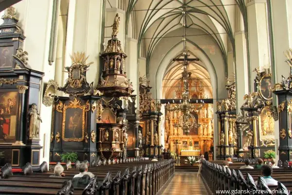 Wnętrze kościoła św. Mikołaja w Gdańsku, pełne bogatych zdobień i ołtarzy.