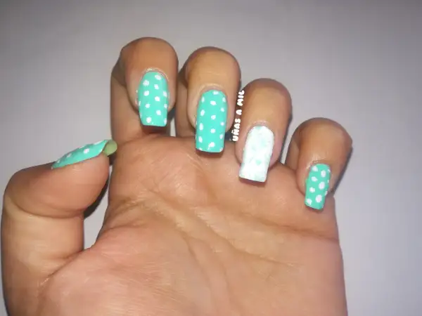 Uñas sevillanas con diseño de lunares turquesa y blanco, y un dedo decorado con un delicado estampado floral.