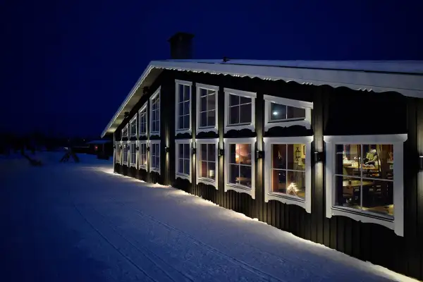 Reftele Wärdshus lyser upp den snöiga kvällen. Varma fönster ger en inblick i en mysig atmosfär.