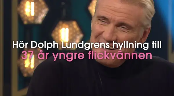 Dolph Lundgren, känd för sin kampsport, ler. Texten lyder: "Hör Dolph Lundgrens hyllning till 37 år yngre flickvännen".