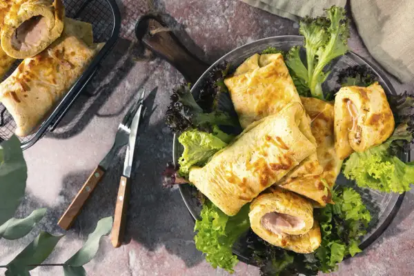 Herzhafte Pfannkuchen, gefüllt mit Schinken und Käse, serviert mit frischem Salat. Ein Genuss für jeden Gaumen!