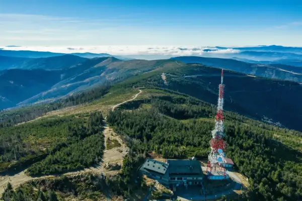 Widok na szczyrk jakie góry, z wieżą telekomunikacyjną i schroniskiem na tle pasm górskich i morza chmur.