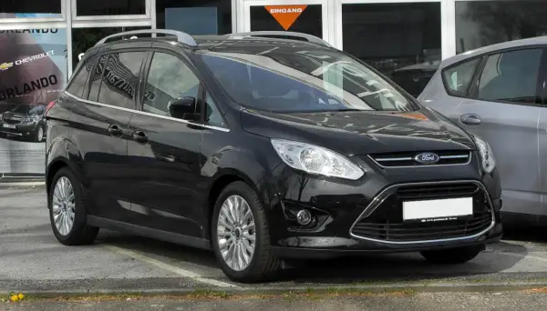 Czarny Ford C-Max na parkingu. Zastanawiasz się nad jego wymiarami? Ten rodzinny van oferuje przestronne wnętrze i praktyczne rozwiązania.