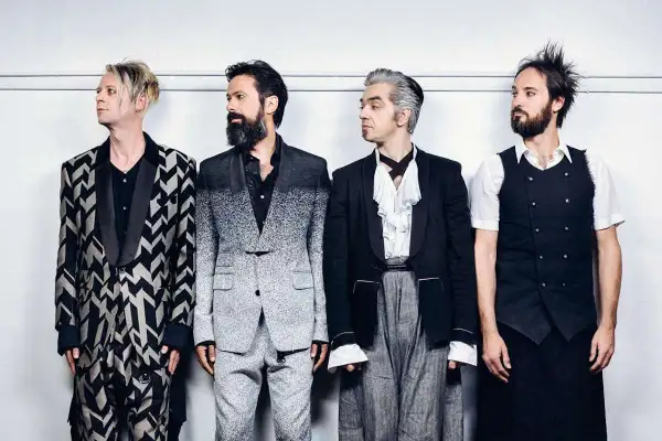 I membri dei Bluvertigo posano in abiti eleganti e audaci, pronti per un nuovo capitolo musicale.