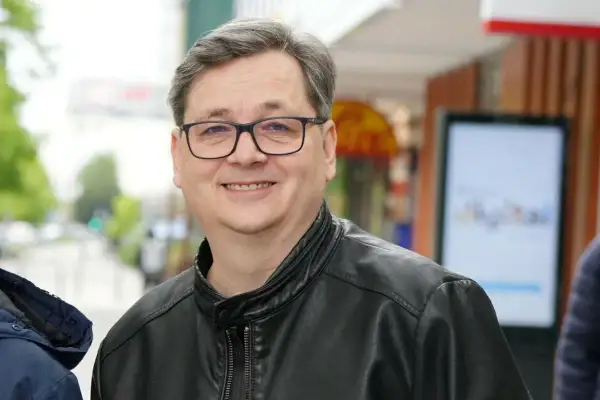 Uśmiechnięty mężczyzna w okularach i skórzanej kurtce. Czy to on wyjaśnia, dlaczego kultowy lektor programu przestał zapowiadać uczestników?