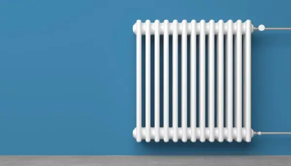 Radiatore bianco su muro blu. Un termotecnico cosa fa? Si assicura che il calore sia distribuito in modo efficiente.