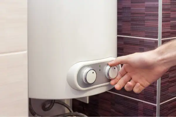 Mano che regola la temperatura di una caldaia a corrente.