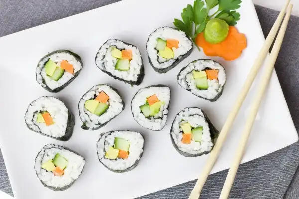 Futomaki co to? Rolki sushi z awokado, ogórkiem i marchewką, podane z wasabi i natką pietruszki.