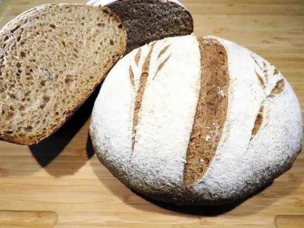 Pane rustico con farina 00, crosta dorata e mollica alveolata, pronto per essere gustato.