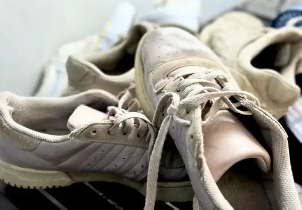 Des baskets beiges un peu usées, prêtes pour un bon nettoyage.