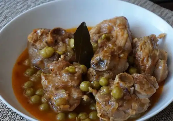 Osobuco de pavo tierno y jugoso, cocinado a fuego lento con guisantes y una hoja de laurel.