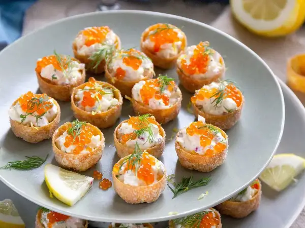 Små krustader fyllda med en krämig mjukoströra, toppade med rom och dill. En festlig förrätt som passar perfekt till mingel.