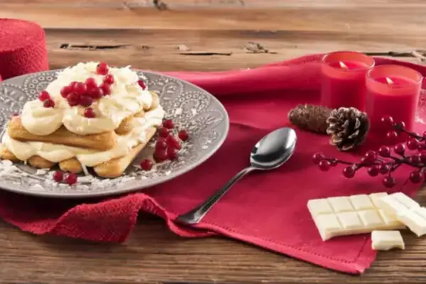 Un délicieux tiramisu chocolat blanc, garni de fruits rouges et de copeaux de chocolat, prêt à être dégusté.