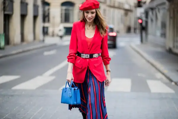 Kvinna i röd kavaj, basker och randig kjol. En perfekt outfit för dresscode kavaj dam.