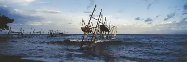 Barcas colgadas en estructuras de madera sobre el mar agitado, un paisaje evocador de lebeche en Rodalquilar.