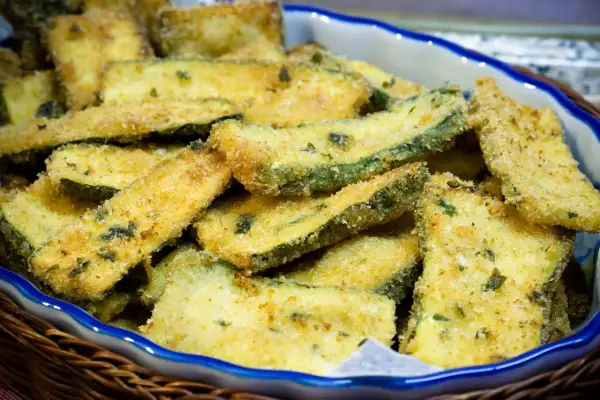 Fettine di zucchine impanate e dorate, pronte per essere gustate. Un contorno sfizioso e leggero, perfetto per ogni occasione.