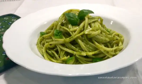 Un piatto invitante di linguine al pesto, condite con basilico fresco, pronte per essere gustate.