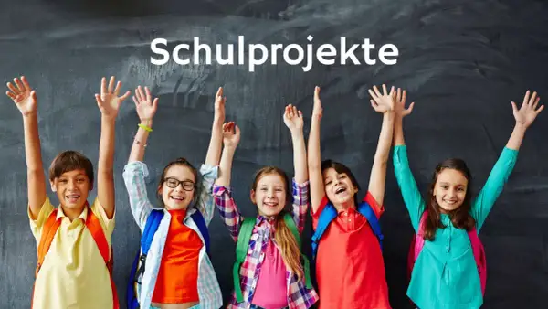 Fünf fröhliche Grundschüler mit Rucksäcken und erhobenen Armen vor einer Tafel, die "Schulprojekte" anzeigt.