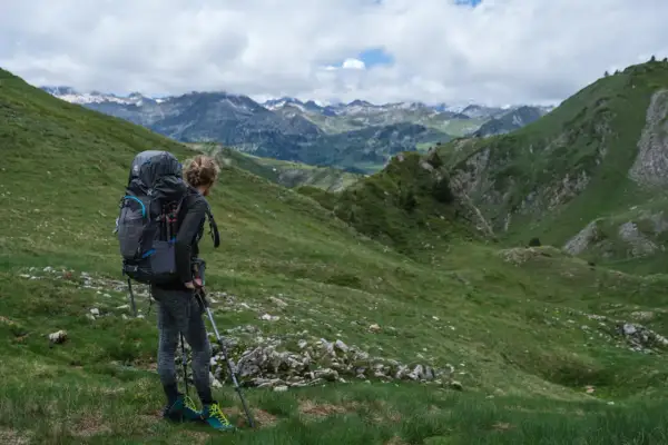 Randonneuse avec un grand sac à dos, prête à explorer les montagnes. Un guide pour comment choisir son sac de randonnée.