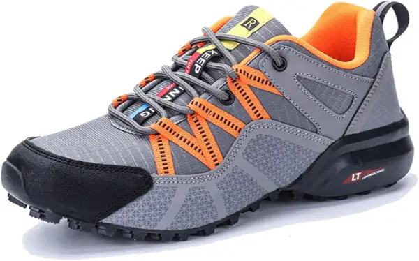 Scarpe da trekking grigie con dettagli arancioni. Il loro significato è comfort e stabilità per ogni avventura.