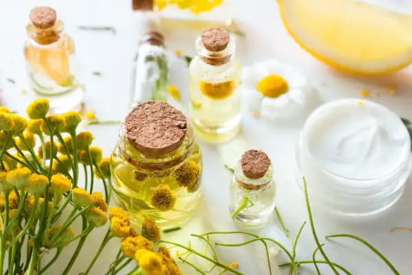 Zutaten für anti-falten augencreme selber machen: Öle, Kräuter, Zitrone und eine Creme.