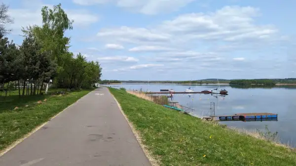 Ścieżka rowerowa wzdłuż jeziora, gdzie cumują żaglówki. Pogoria 4 zaprasza do aktywnego wypoczynku.