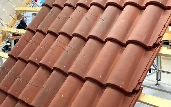 Detalle de la colocación teja árabe, con alambres finos sujetando las piezas sobre una estructura de madera.