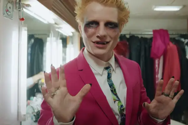 Ed Sheeran w różowej marynarce i makijażu wampira, gotowy do wykonania swoich największych przebojów.