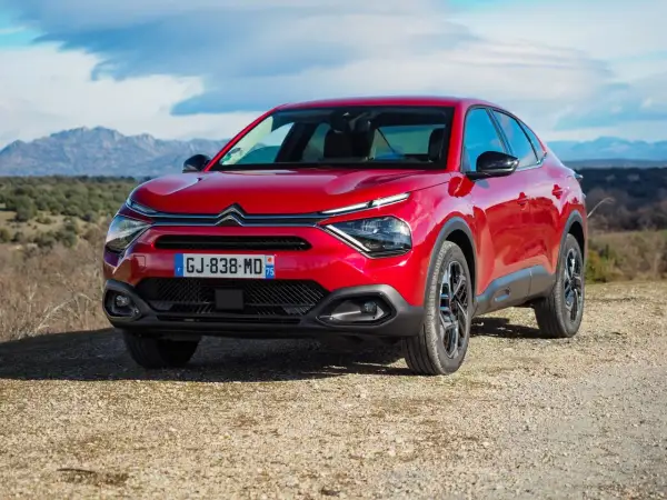 Czerwony Citroën C4X na tle górskiego krajobrazu.