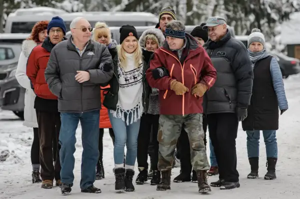Grupa seniorów i młodszych osób spaceruje w zimowej scenerii. Czy to zapowiedź, kiedy jest powtórka Sanatorium Miłości?