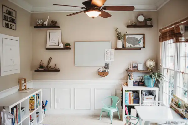 Inspiring modern homeschool room ideas: shelves with decor, a whiteboard, and organized storage create a functional and beautiful learning space.