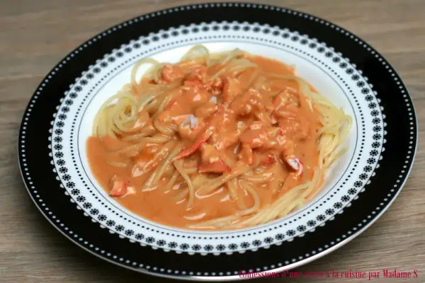 Pâtes au homard crémeuses, un délice servi dans une assiette décorée.