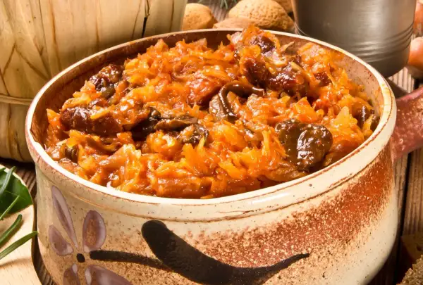 Pyszny bigos bez mięsa w glinianym naczyniu, pełen kapusty i grzybów.
