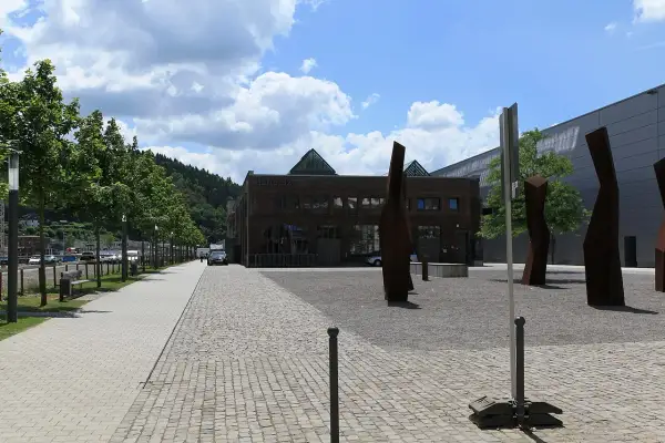 Die Halle 32 mit ihren markanten Glaspyramiden, umgeben von Bäumen und Skulpturen, an einem sonnigen Tag.