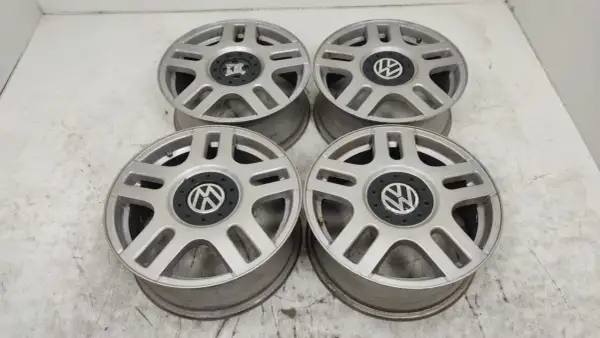Cztery srebrne felgi aluminiowe Volkswagen z czarnym środkiem i logo VW.