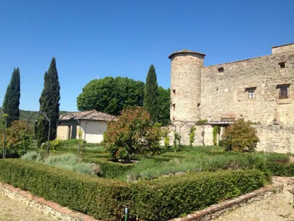 Giardino all'italiana con torre medievale, un luogo dove i sogni del Chianti prendono vita tra siepi curate e profumi di lavanda.
