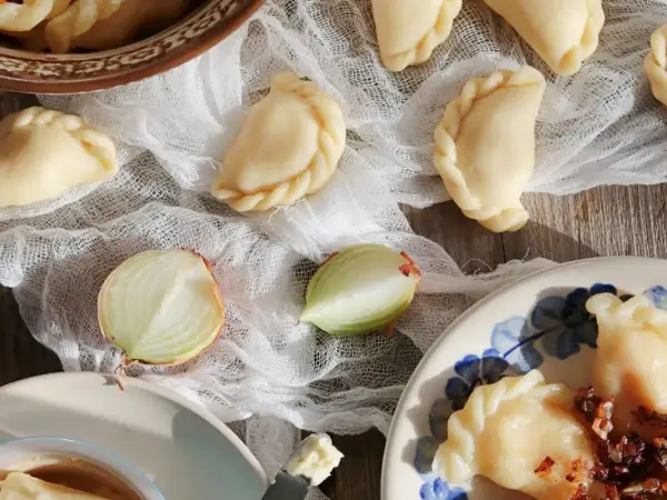 Gotowe pierogi ruskie, cebula i masło. Idealne na obiad, zgodnie z przepisem na pierogi ruskie.
