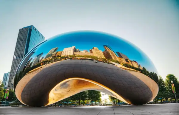 Lśniące dzieła Anish Kapoor odbijają panoramę miasta.